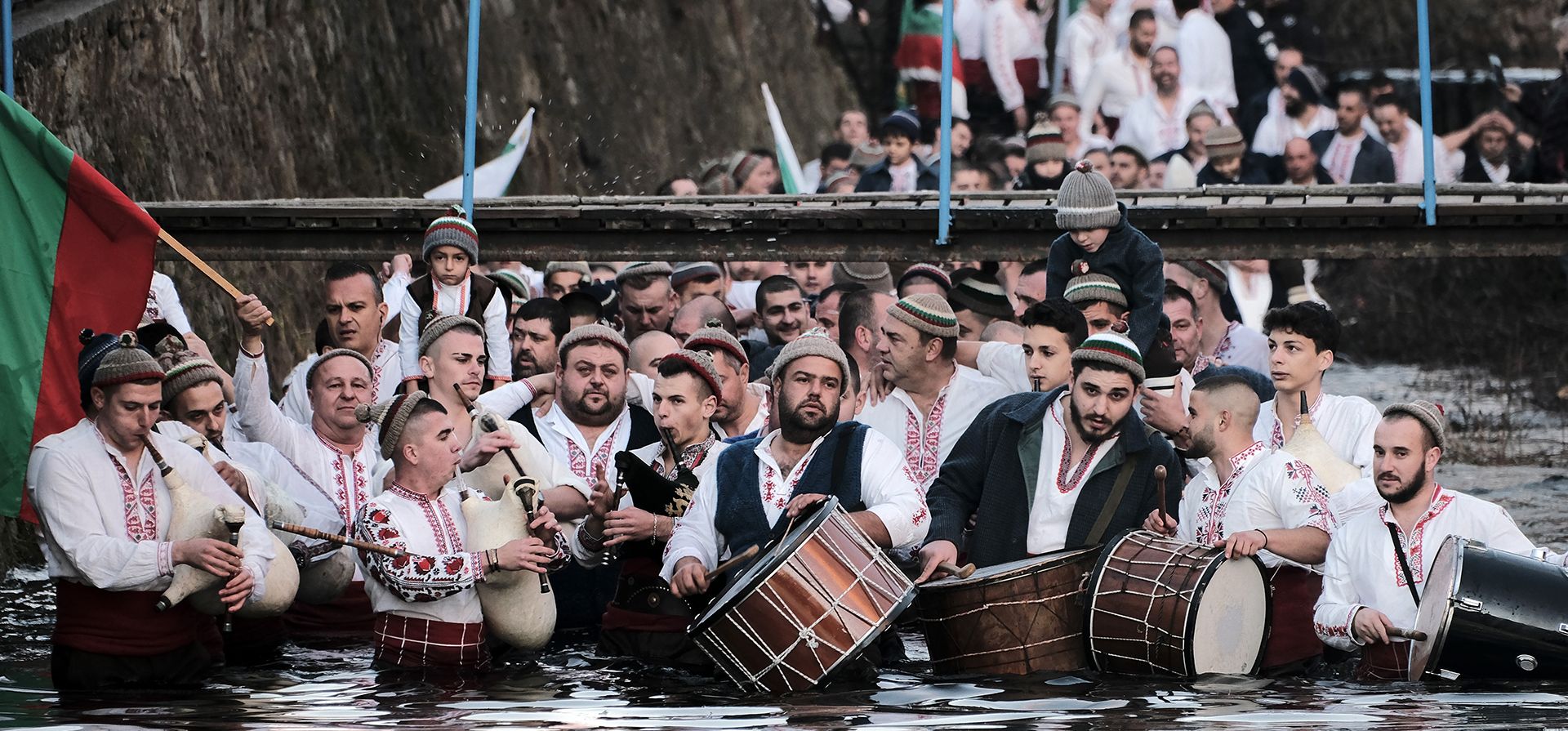 Un grupo de hombres tocan gaitas y tambores mientras forman una procesión hacia el frío río Tundzha para celebrar la Epifanía en la ciudad de Kalofer, el viernes 6 de enero de 2023. (Foto AP/Alexander Nikolov)