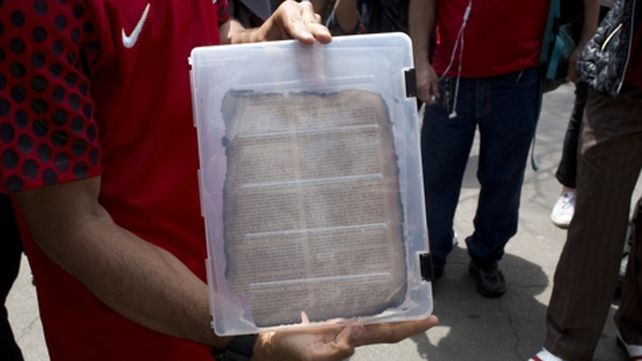 Desolador. Un joven muestra una página de una obra quemada.