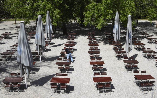 Un empleado prepara los bancos y mesas para la reapertura de la taberna al aire libre