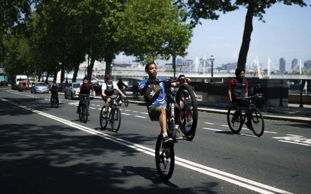 Un grupo de niños andan en bicicleta a lo largo del Embankment, en Londres.
