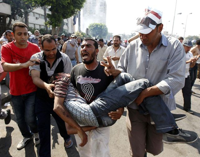 Un egipcio gravemente herido es trasladado por sus compañeros cerca de la plaza Tahrir.