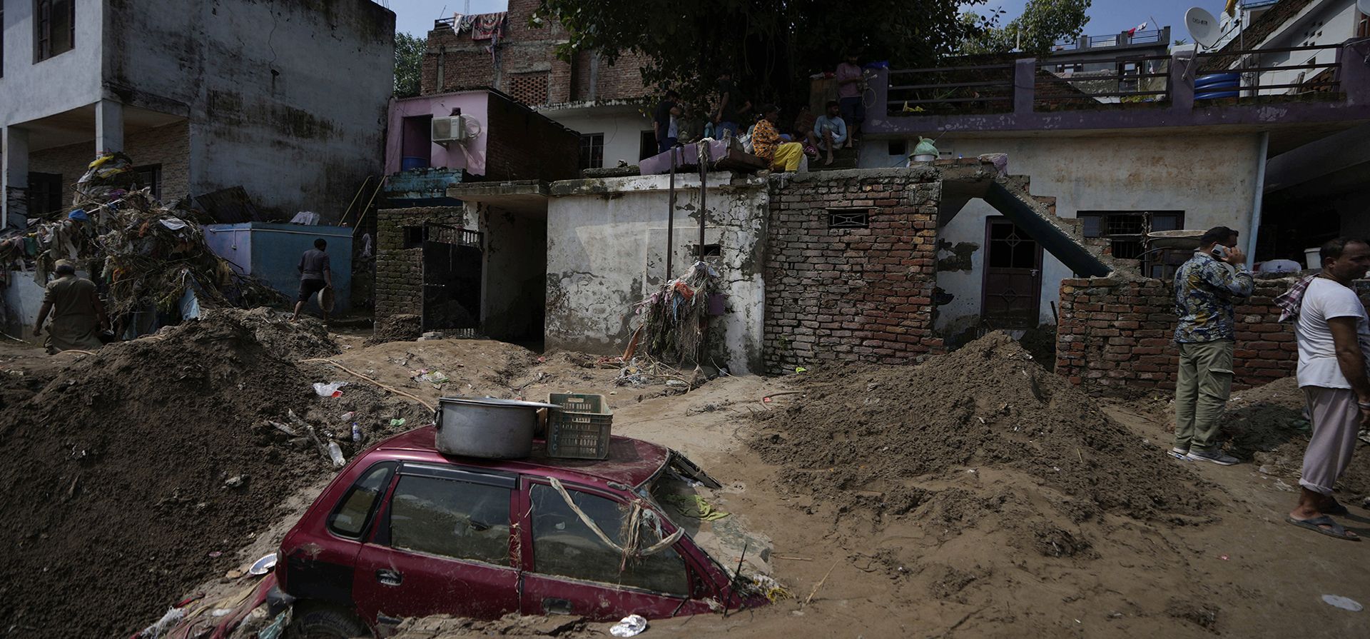 Personas limpian el lodo de sus casas mientras un automóvil permanece atrapado entre los escombros tras las inundaciones repentinas a lo largo de las orillas del río Tawi en Jammu, India, el jueves 28 de agosto de 2025. (Foto AP/Channi Anand) Personas limpian el lodo de sus casas mientras un automóvil permanece atrapado entre los escombros tras las inundaciones repentinas a lo largo de las orillas del río Tawi en Jammu, India, el jueves 28 de agosto de 2025. (Foto AP/Channi Anand)