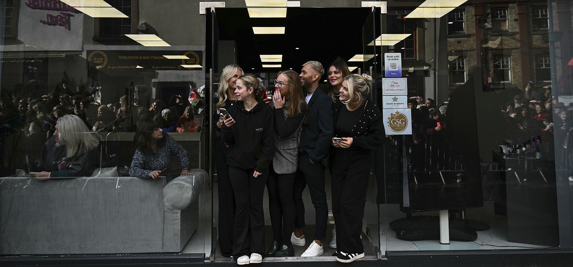 La gente observa al príncipe Guillermo de Gran Bretaña y a Kate, princesa de Gales, saludar a sus simpatizantes durante una visita al mercado de Pontypridd, en el sur de Gales, el miércoles 26 de febrero de 2025. (Ben Stansall/Pool Photo vía AP)