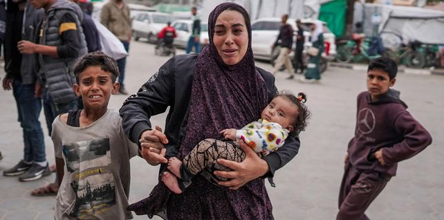 Una mujer palestina sostiene a su hija fuera de un hospital después de un bombardeo israelí, Bureij, Gaza. Fotografía: AFP/Getty Images