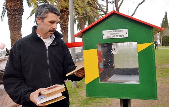 Visita permanente. Enrique junto a la biblioteca pública que colocó su hijo Mariano en Entre Ríos y el río. Siempre va allí a recordarlo.
