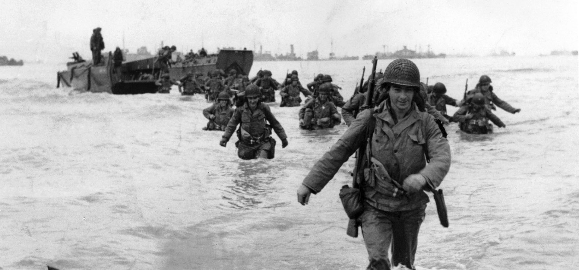 ARCHIVO - Soldados de infantería de EE. UU. se abren paso entre las olas mientras desembarcan en Normandía en los días posteriores a la invasión del Día D de junio de 1944 por parte de los Aliados en la Francia ocupada. (Foto AP/Bert Brandt, archivo) ARCHIVO - Soldados de infantería de EE. UU. se abren paso entre las olas mientras desembarcan en Normandía en los días posteriores a la invasión del Día D de junio de 1944 por parte de los Aliados en la Francia ocupada. (Foto AP/Bert Brandt, archivo)