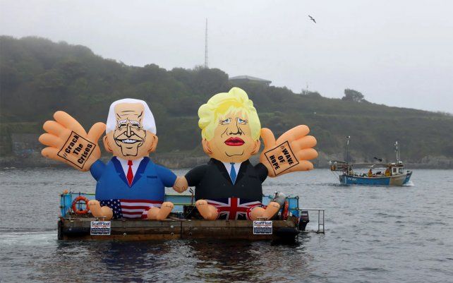 Muñecos inflables que representan al presidente Biden y Boris Johnson se muestran en un bote en la playa de Gyllyngvase en Falmouth. Fotografía: Tom Nicholson / Reuters