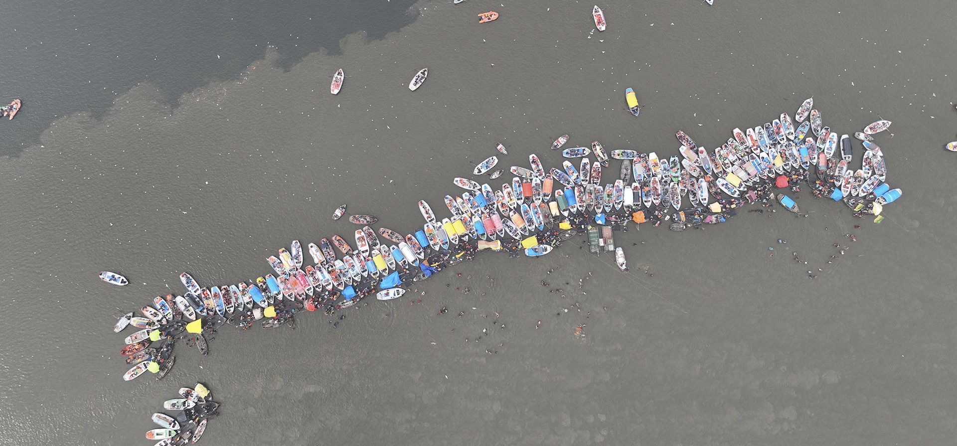 Peregrinos y turistas toman paseos en bote para darse baños rituales en Sangam, la confluencia de tres ríos Ganges, el Yamuna y el mítico Saraswati, durante el día de Basant Panchami, en la tradicional feria anual de Magh Mela en Prayagraj, en el norteño estado indio de Uttar Pradesh, jueves 26 de enero de 2023. (Foto AP/Rajesh Kumar Singh)