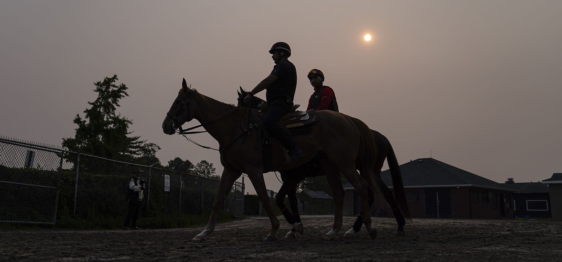 La neblina de los incendios forestales del norte oscurece el sol naciente mientras los jinetes conducen sus monturas hacia la pista antes de la carrera de caballos Belmont Stakes, el miércoles 7 de junio de 2023, en Belmont Park en Elmont, Nueva York (AP Photo/John Minchillo) La neblina de los incendios forestales del norte oscurece el sol naciente mientras los jinetes conducen sus monturas hacia la pista antes de la carrera de caballos Belmont Stakes, el miércoles 7 de junio de 2023, en Belmont Park en Elmont, Nueva York (AP Photo/John Minchillo)
