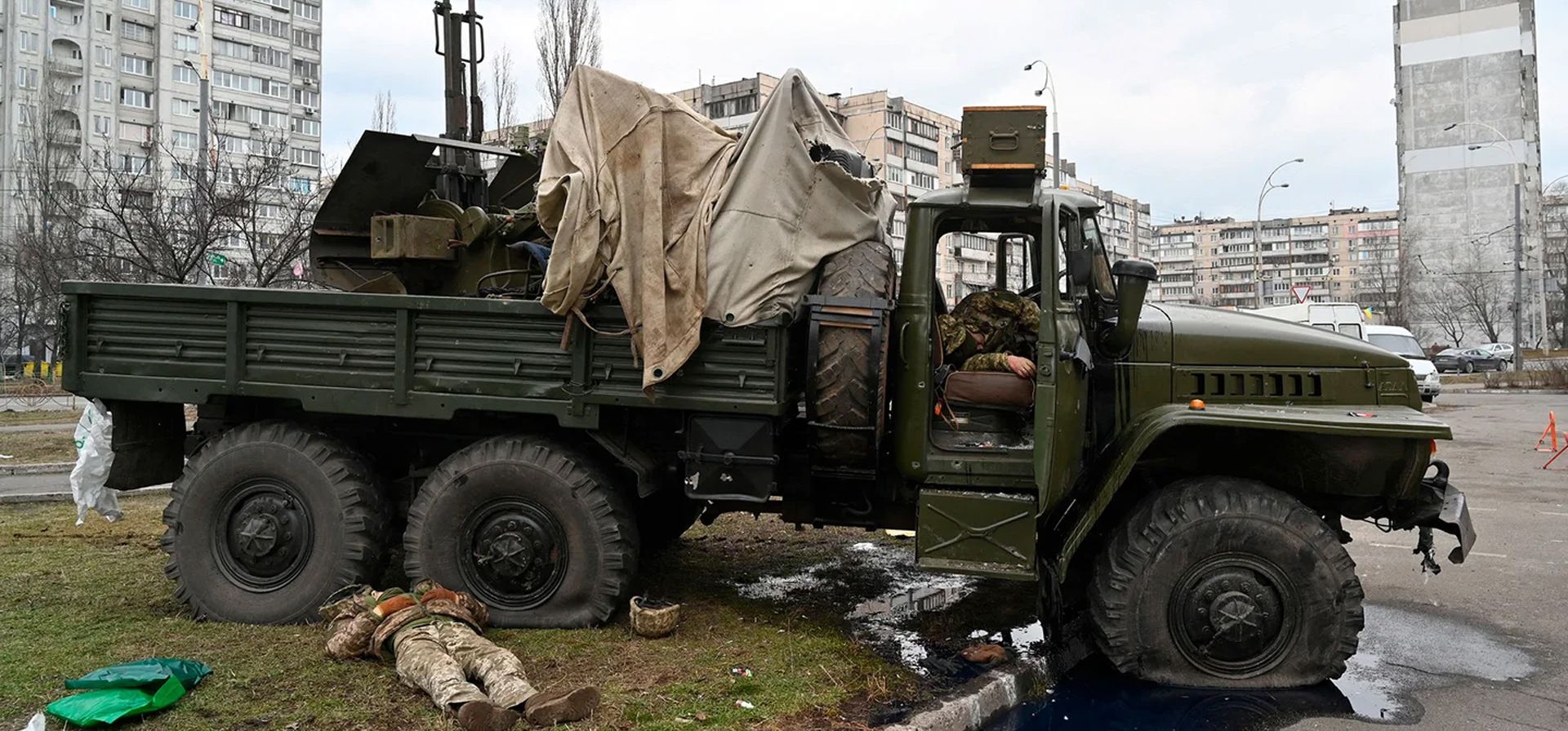 Los cuerpos de los militares rusos con uniforme de servicio ucraniano yacen al lado y dentro de un vehículo después de que de un grupo de asalto disparó durante una escaramuza en la capital ucraniana de Kiev el 25 de febrero de 2022.
