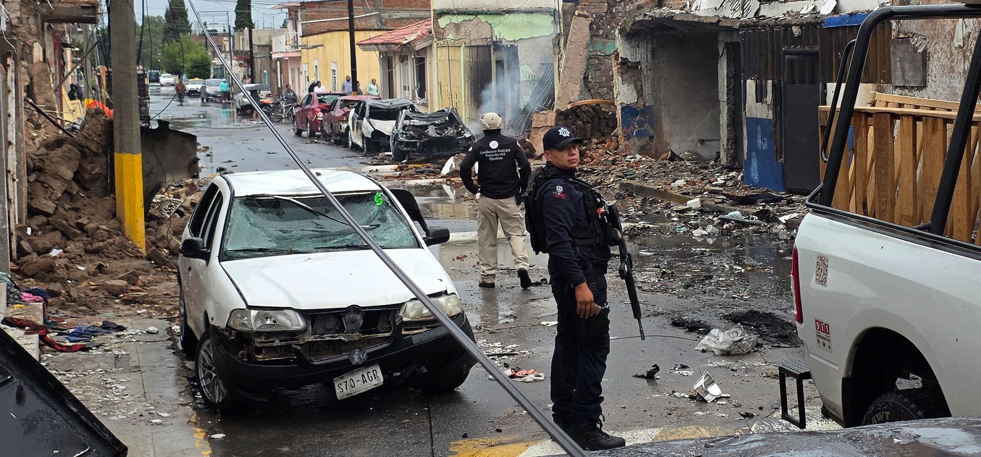 Agentes de policía se encuentran frente a una comisaría municipal dañada tras la explosión de un coche bomba durante la noche en Ojocaliente, en el estado de Zacatecas, México, el lunes 31 de agosto de 2026. (AP Foto/Eduardo Pesci)