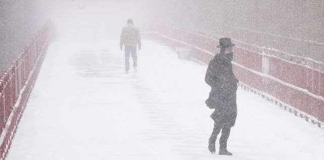 La gente cruza el puente de Williamsburg durante la tormenta de nieve en Nueva York. 