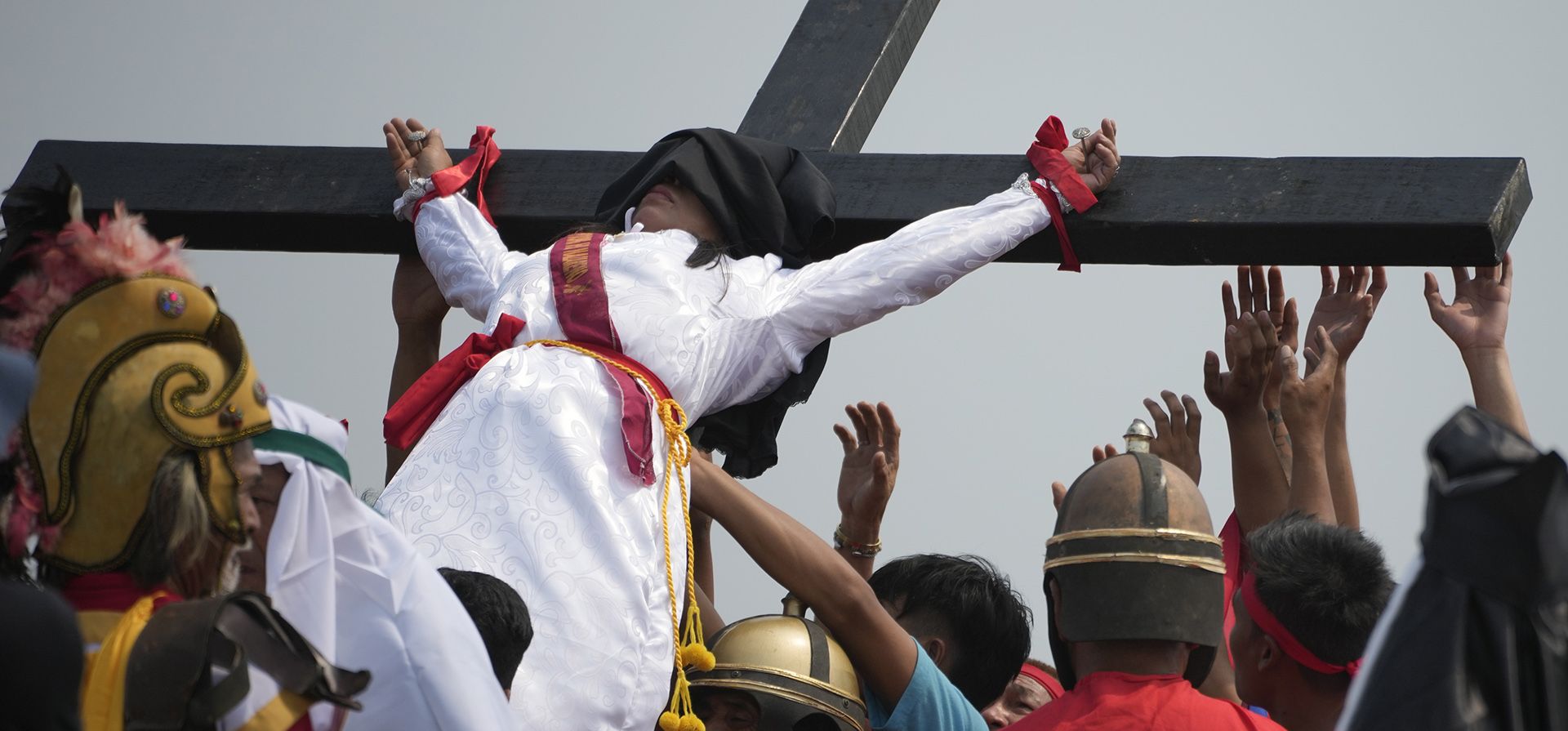 Una mujer penitente que está clavada en una cruz de madera durante una recreación de los sufrimientos de Jesucristo como parte de los rituales del Viernes Santo el 7 de abril de 2023 en el pueblo de San Pedro, Cutud, provincia de Pampanga, al norte de Filipinas.(AP Photo/Aaron Favila)