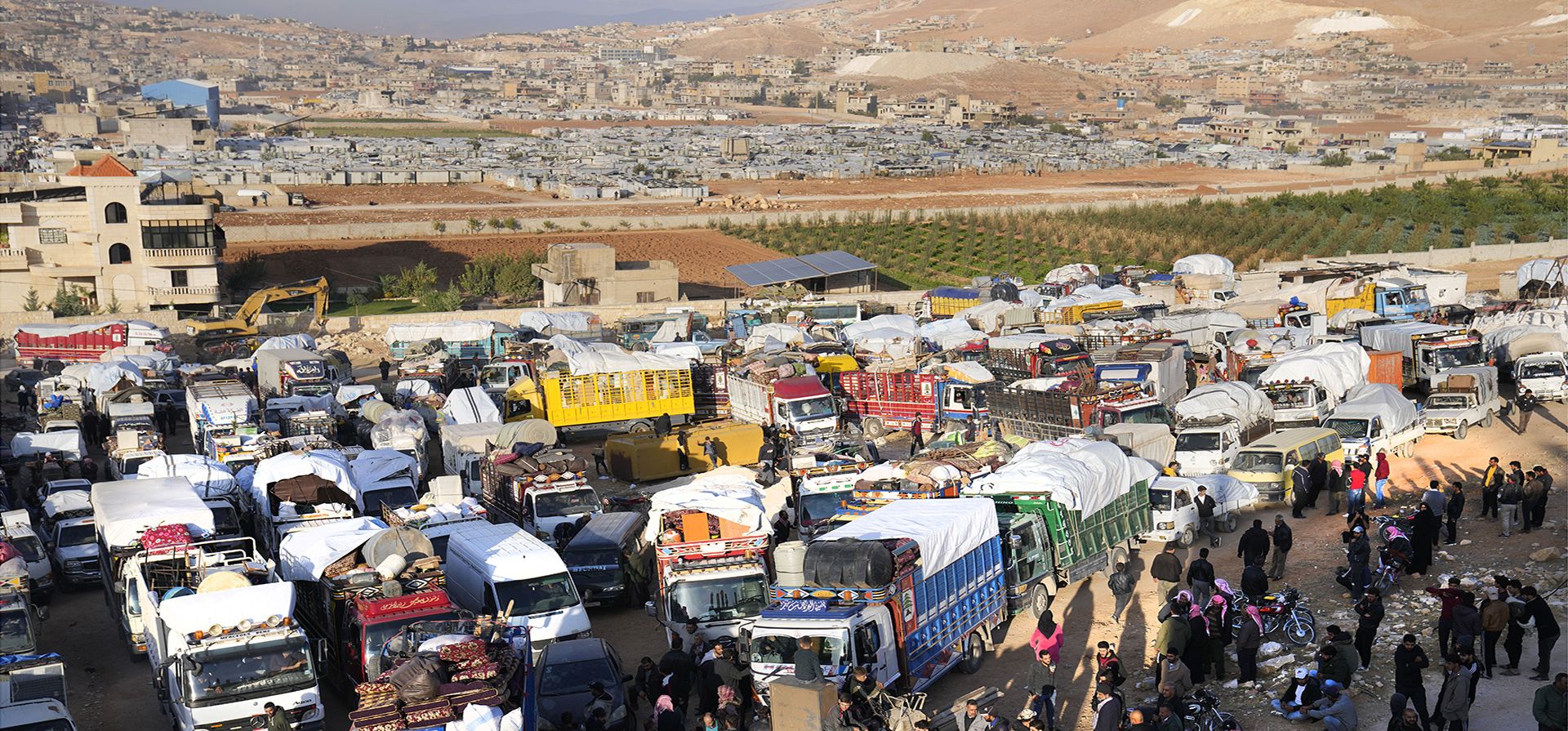 Refugiados sirios se reúnen cerca de camiones, mientras se preparan para regresar a Siria, en la ciudad fronteriza libanesa oriental de Arsal, Líbano, el miércoles 26 de octubre de 2022.