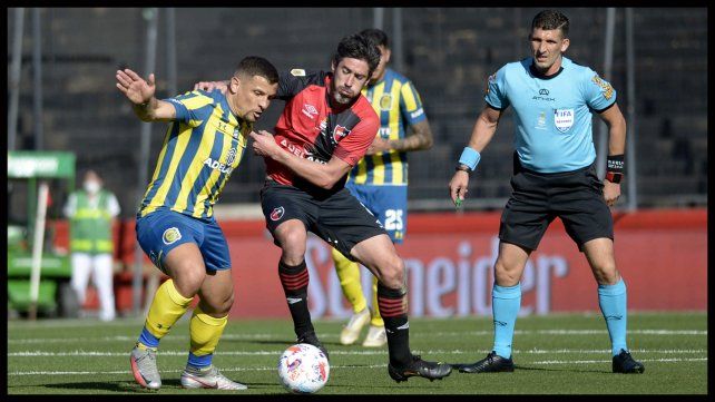Pablo Pérez intenta detener a Emiliano Vecchio ante la mirada del cuestionado árbitro Andrés Merlos.