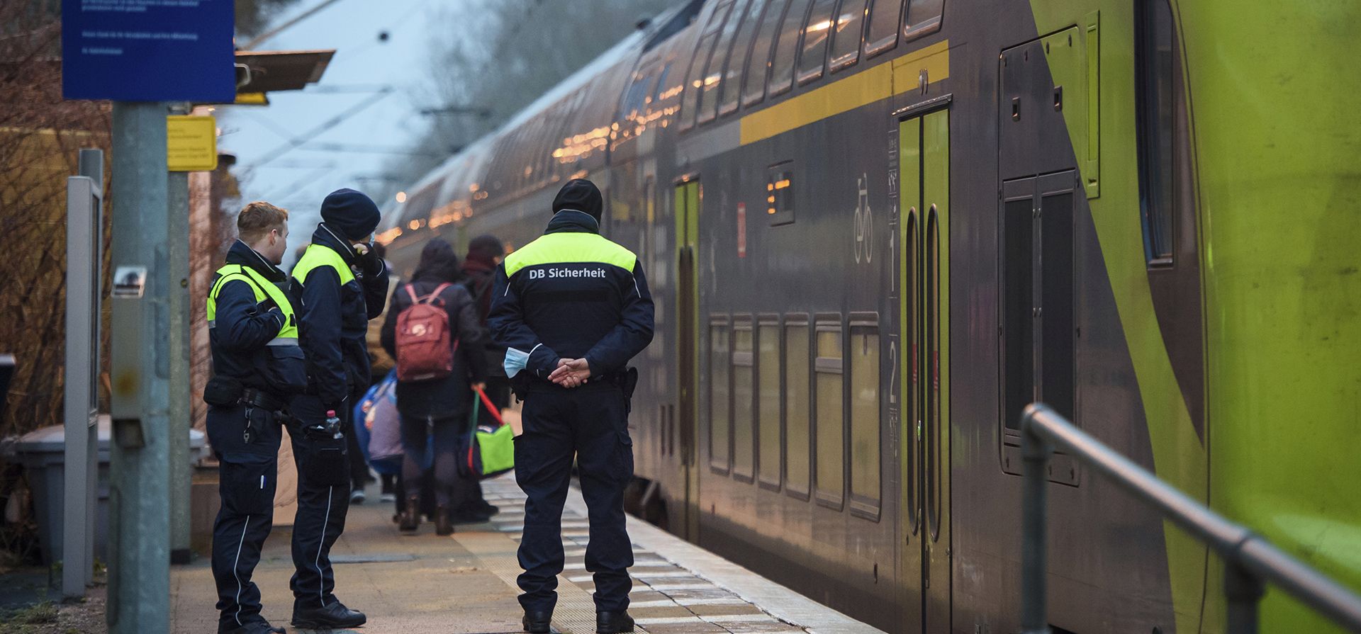 Guardias de seguridad de Deutsche Bahn se paran en el andén de la estación Brokstedt al amanecer en Brokstedt, Alemania, el jueves 26 de enero de 2023. Dos personas murieron y siete resultaron heridas en un ataque con cuchillo en un tren regional de Kiel a Hamburgo. (Gregor Fischer/dpa vía AP)