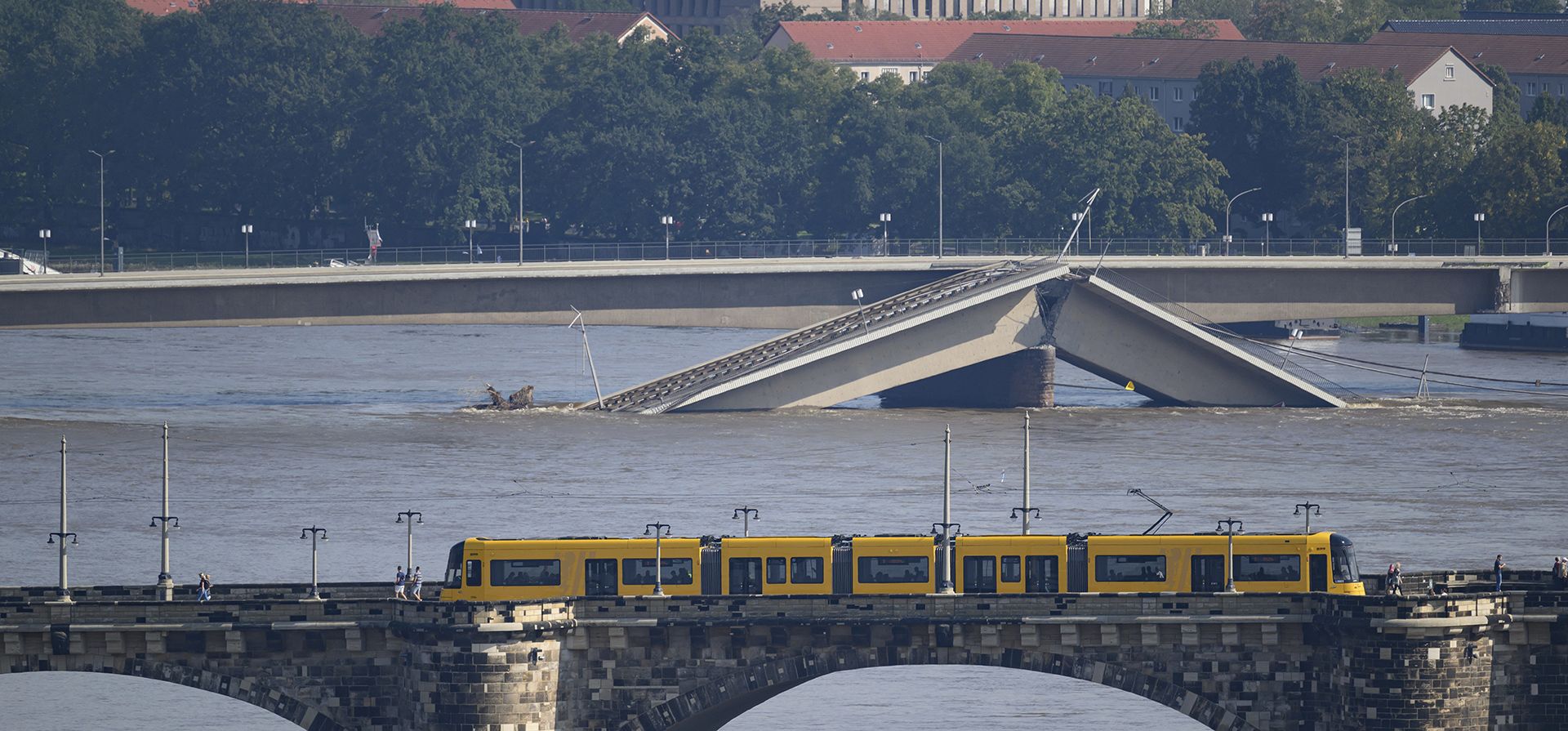 Un tranvía de la Autoridad de Transporte de Dresde (DVB) cruza el Puente Augustus con una vista del Elba inundado fluyendo a lo largo del Puente Carola parcialmente derrumbado, al fondo, en Dresde, Alemania, el miércoles 18 de septiembre de 2024. (Robert Michael/dpa vía AP) Un tranvía de la Autoridad de Transporte de Dresde (DVB) cruza el Puente Augustus con una vista del Elba inundado fluyendo a lo largo del Puente Carola parcialmente derrumbado, al fondo, en Dresde, Alemania, el miércoles 18 de septiembre de 2024. (Robert Michael/dpa vía AP)