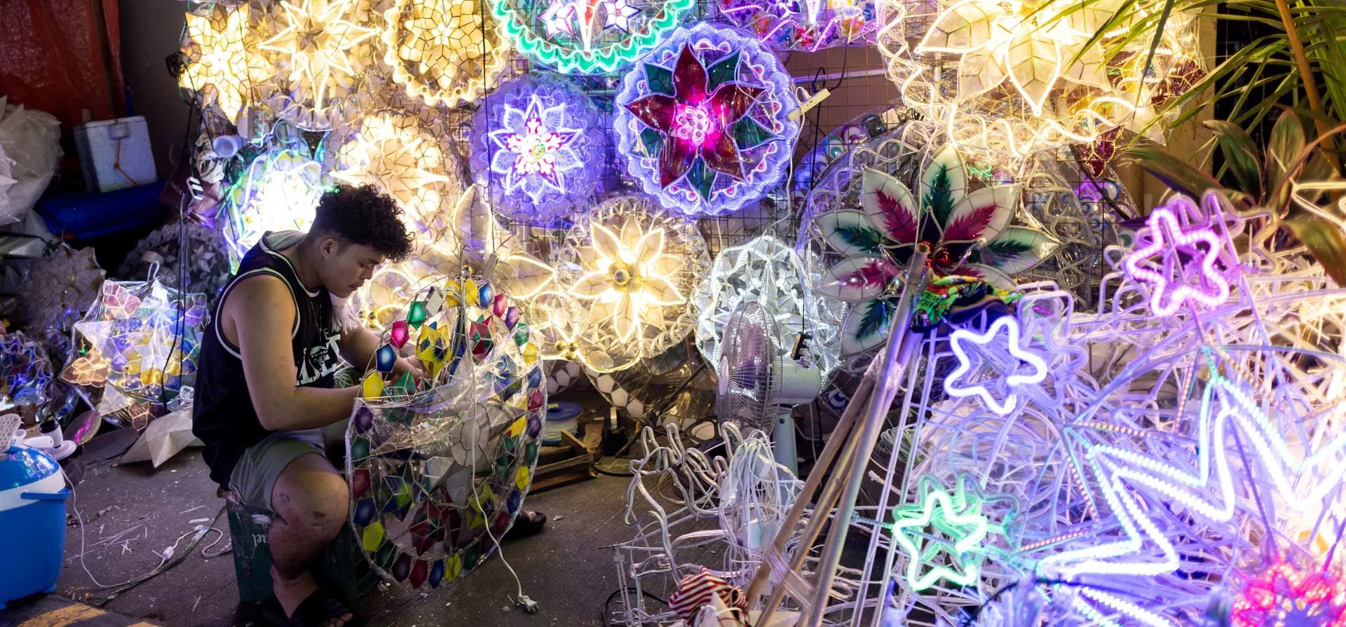 Un vendedor trabaja en farolillos de estrellas navideñas en un mercado callejero, Quezon, Filipinas. Fotografía: Eloísa López/Reuters Un vendedor trabaja en farolillos de estrellas navideñas en un mercado callejero, Quezon, Filipinas. Fotografía: Eloísa López/Reuters