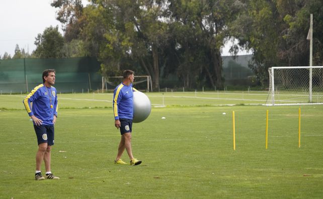 Claudio Ubeda acompaña a Juan Pablo Sena, uno de los utileros, en la previa de un entrenamiento.