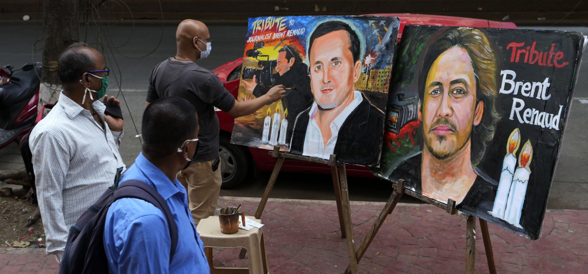 El profesor de arte indio Sagar Kambli realiza una pintura del aclamado cineasta Brent Renaud, quien murió el domingo después de que las fuerzas rusas abrieron fuego contra su vehículo en Ucrania, mientras le rinde homenaje en una calle Mumbai, India, el lunes 14 de marzo de 2022.