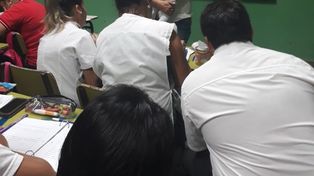 El preciso momento cuando la profesora carga en brazos a la criatura para que la joven madre y alumna pueda seguir con atención la clase que se desarrollaba.