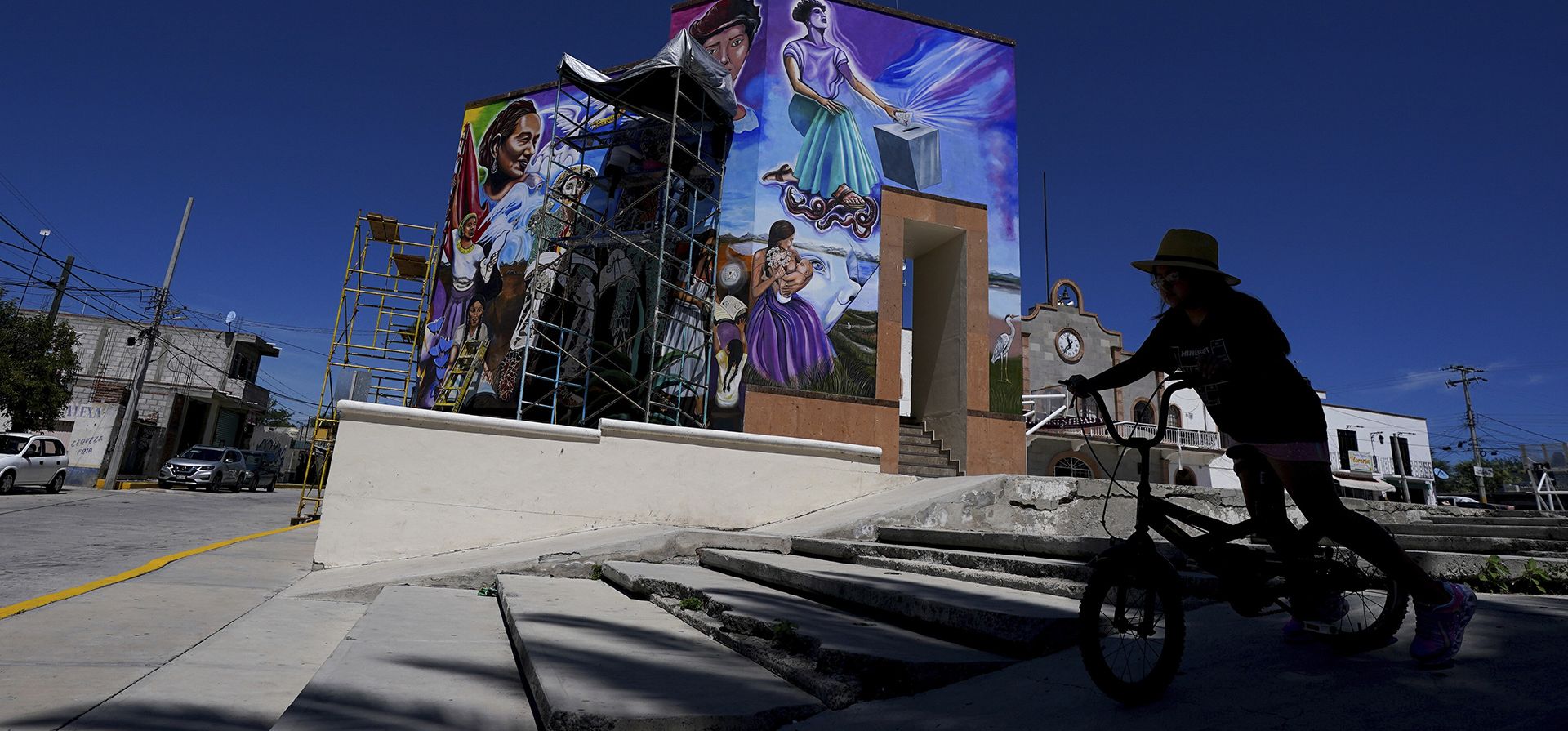 Una niña monta su bicicleta frente a un mural pintado por el artista mexicano Jesús Rodríguez, en San Salvador, México. Artistas que ayudan a revivir el muralismo o las imágenes visuales para compartir mensajes de importancia social y política, un movimiento que puso a México a la vanguardia del arte hace un siglo.
