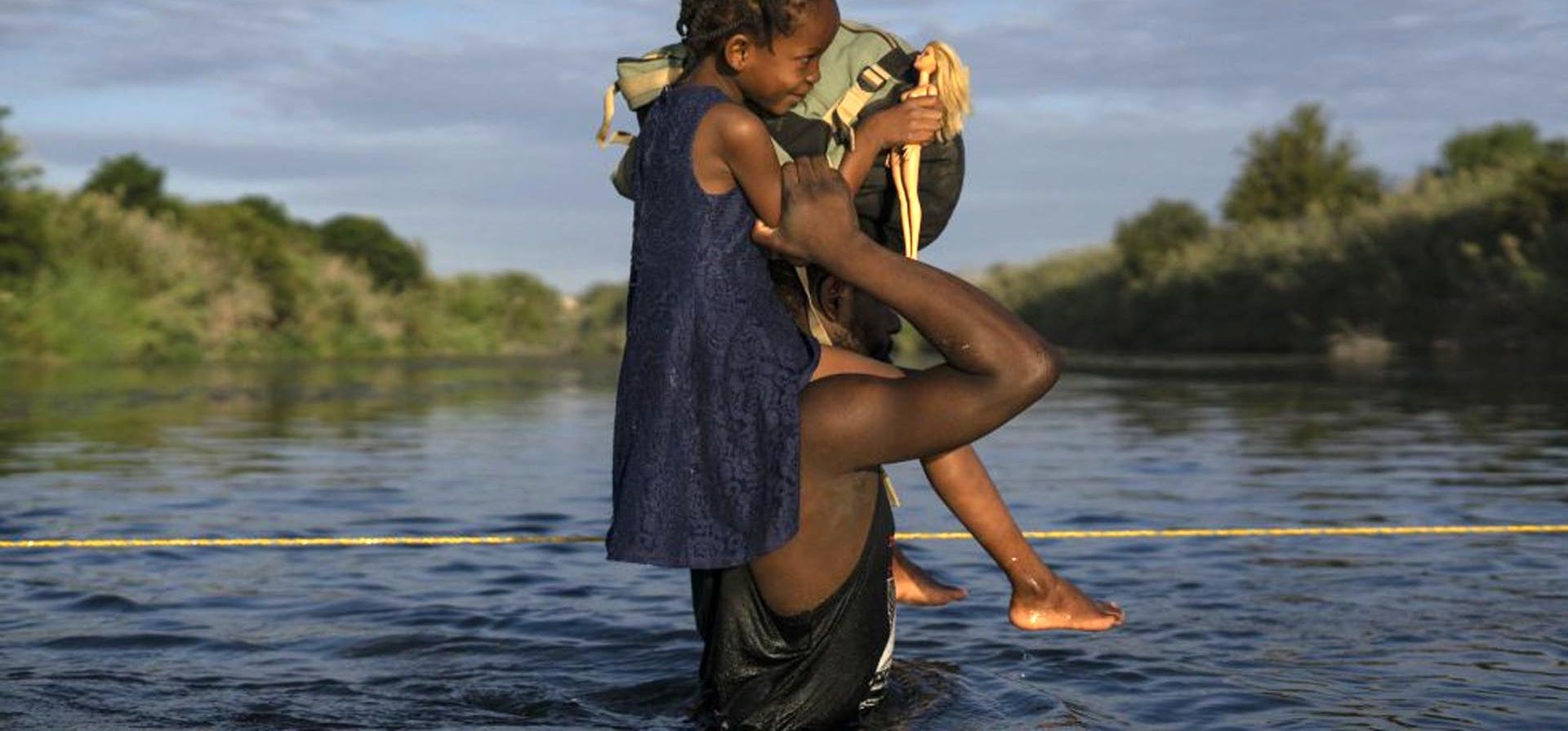 Un hombre con su hija a hombros cruza el Río Bravo entre Del Río (Texas) y Ciudad Acuña (México), este 22 de septiembre. La situación de los migrantes que quieren ingresar a Estados Unidos cada vez es mas angustiante y dificil de resolver por las autoridades de los dos países. Foto: AFP