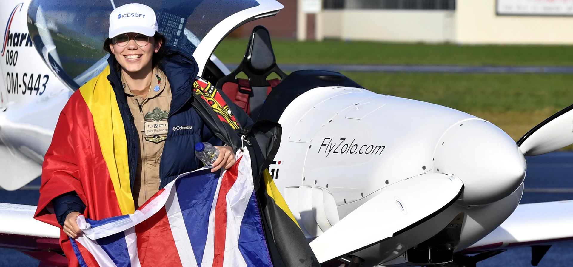 La piloto adolescente belga-británica Zara Rutherford ondea la bandera belga y británica, después de aterrizar su avión ultraligero Shark en el aeropuerto de Kortrijk, Bélgica, el jueves 20 de enero de 2022. La piloto belga-británica Zara, de 19 años Rutherford ha establecido un récord mundial como la mujer más joven en volar sola alrededor del mundo, a 155 días después de su partida. Rutherford se encontrará en el libro Guinness World Records después de establecer la marca que había tenido la aviadora estadounidense de 30 años Shaesta Waiz desde 2017.