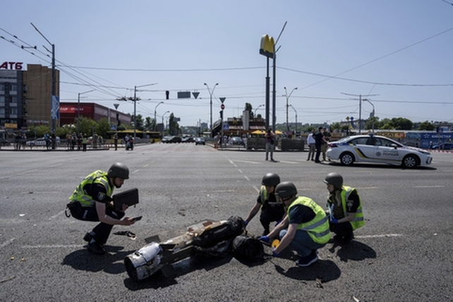 Fuerzas de seguridad inspeccionan los restos de un misil ruso derribado sobre Kiev. 