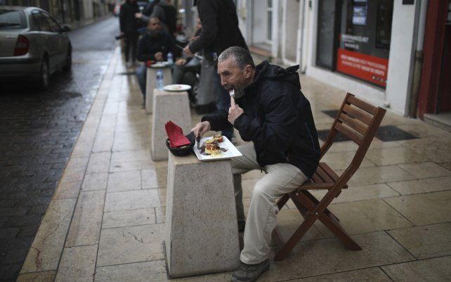 La gente almuerza fuera de una pizzería en Marignane, en el sur de Francia. El primer ministro francés, Jean Castex, ordenó que se intensificaran los controles policiales de quienes violan el toque de queda de 12 horas al día en Francia.