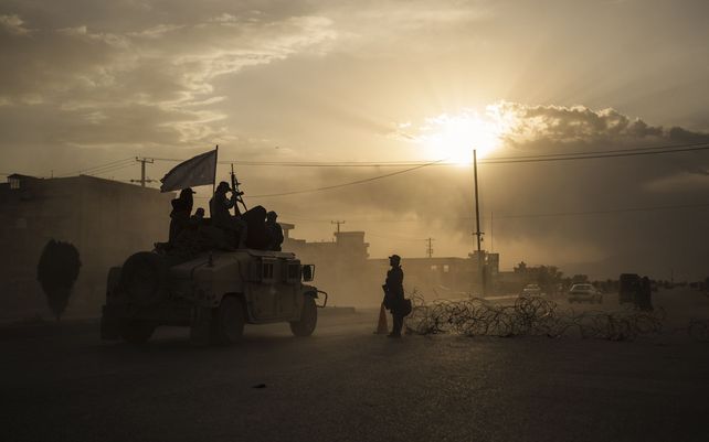 Combatientes talibanes viajan sobre un Humvee camino a detener a afganos involucrados en una pelea callejera en Kabul