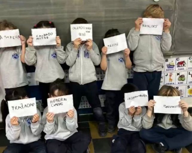 Nenes y nenas muestran los carteles que utilizaron para rotular los calzados y vestimentas que lograron recabar.