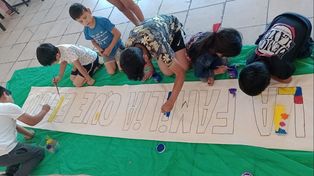 Los niños y niñas del barrio Qom de Travesía pintar un cartel para celebrar este martes el Dìa de la Familia.&nbsp;