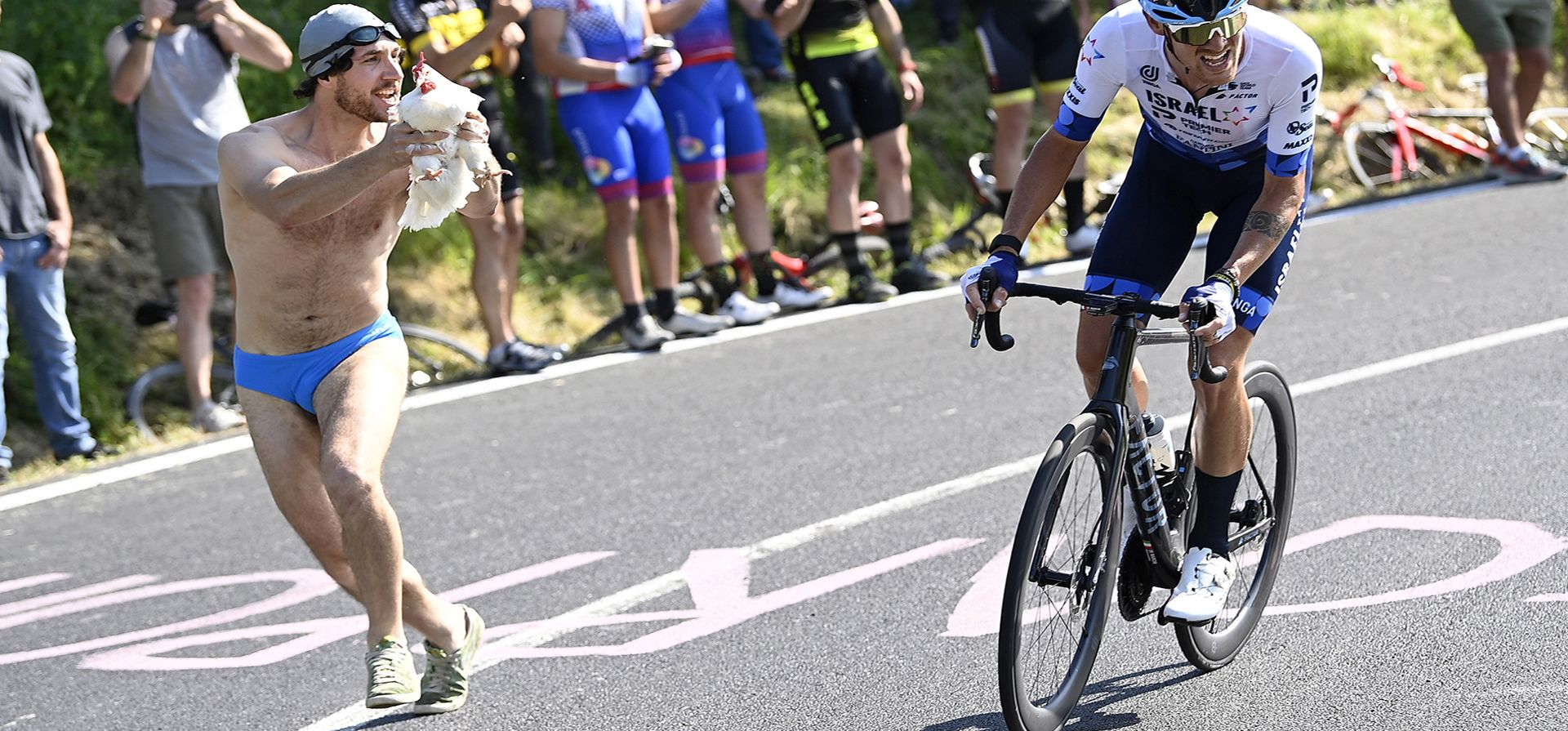 Un hombre le muestra una gallina al italiano Alessandro De Marchi mientras pedalea durante la décima etapa de la carrera ciclista Giro D