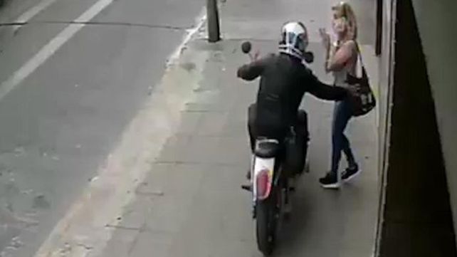 La escena es elocuente: el motochorro le saca la cartera a la mujer
