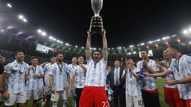 El gran arquero del seleccionado nacional, Dibu Martínez, alza hacia lo más alto el trofeo de la Copa América.