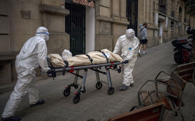 Los trabajadores de la morgue trasladan el cuerpo de una persona mayor que murió de COVID-19 después de sacarlo de un hogar de ancianos en Barcelona