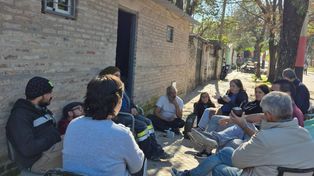 Voluntarios del refugio Sol de Noche comparten un mate en el frente del nuevo espacio en Repúplica de la sexta
