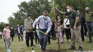 El intendente Pablo Javkin planta un árbol durante la ceremonia realizada en el Bosque de la Memoria.