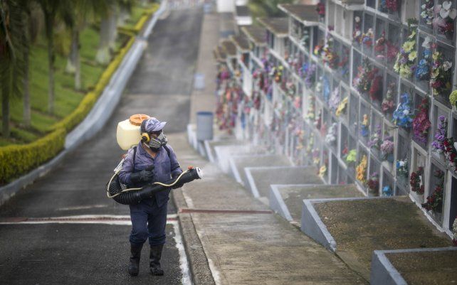 Un trabajador rocía desinfectante en los nichos del cementerio de Nuestra Señora de Belén como medida preventiva en medio de la pandemia de COVID-19 en Fusagasugá, Colombia.