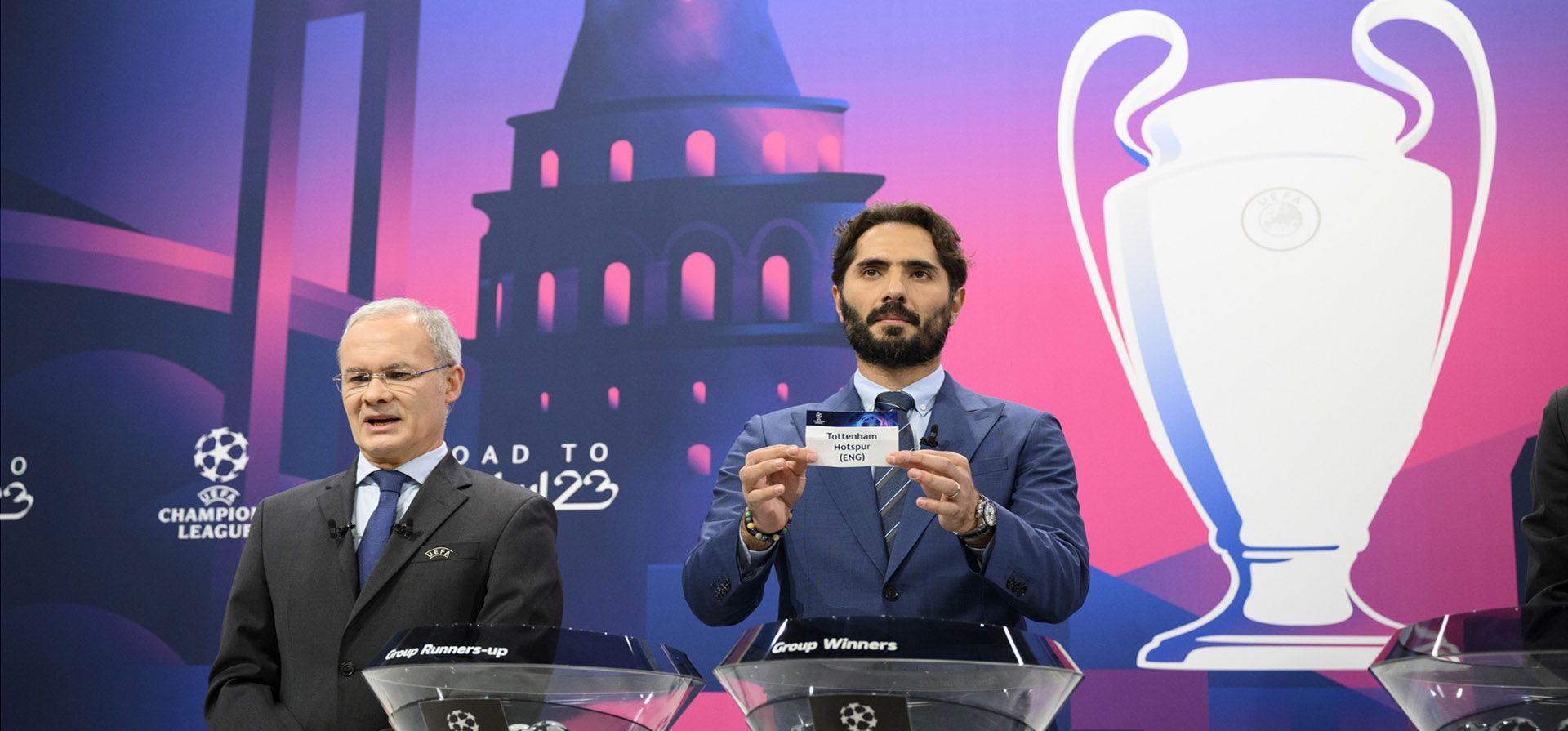 El futbolista turco y embajador de la final de la UEFA Champions League en Estambul, Hamit Altintop, muestra una entrada del club de fútbol inglés Liverpool FC junto al subsecretario general de la UEFA, Giorgio Marchetti, durante el sorteo de octavos de final de la UEFA Champions League 2022/23, en el Sede de la UEFA en Nyon, Suiza, el lunes 7 de noviembre de 2022.
