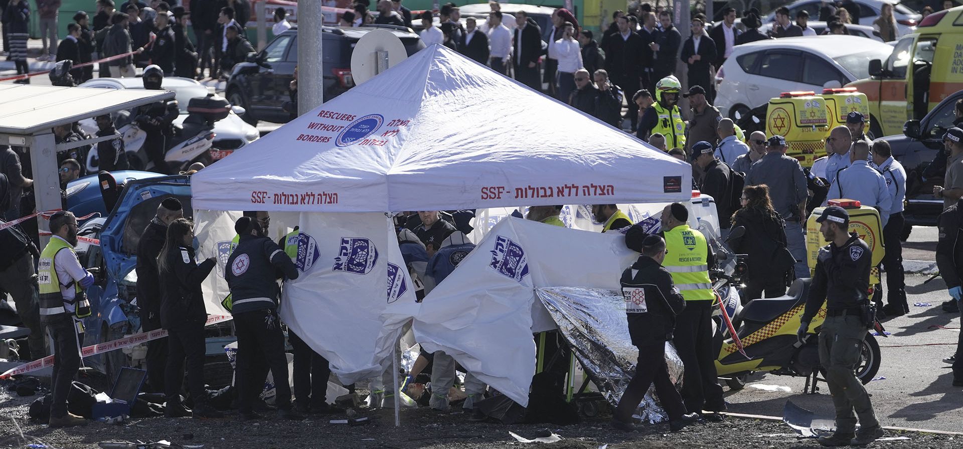 Los miembros del equipo de Rescate y Recuperación de Zaka trabajan en el sitio de un ataque de atropello de automóvil en una parada de autobús en Ramot, un asentamiento judío en el este de Jerusalén, el viernes 10 de febrero de 2023. (AP Photo/Mahmoud Illean