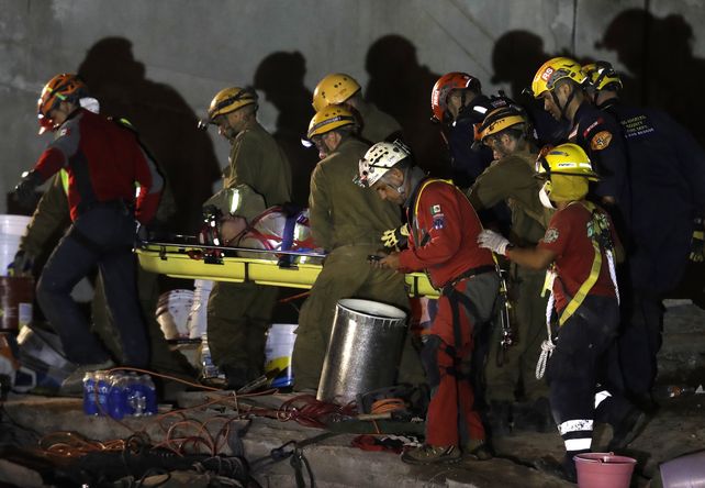Rescatistas trasladan a una mujer bombera herida en uno de los derrumbes.&nbsp;