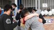El dolor resumido en un abrazo por la muerte de la adolescente. Detr&aacute;s, los carteles con pedidos de justicia.
