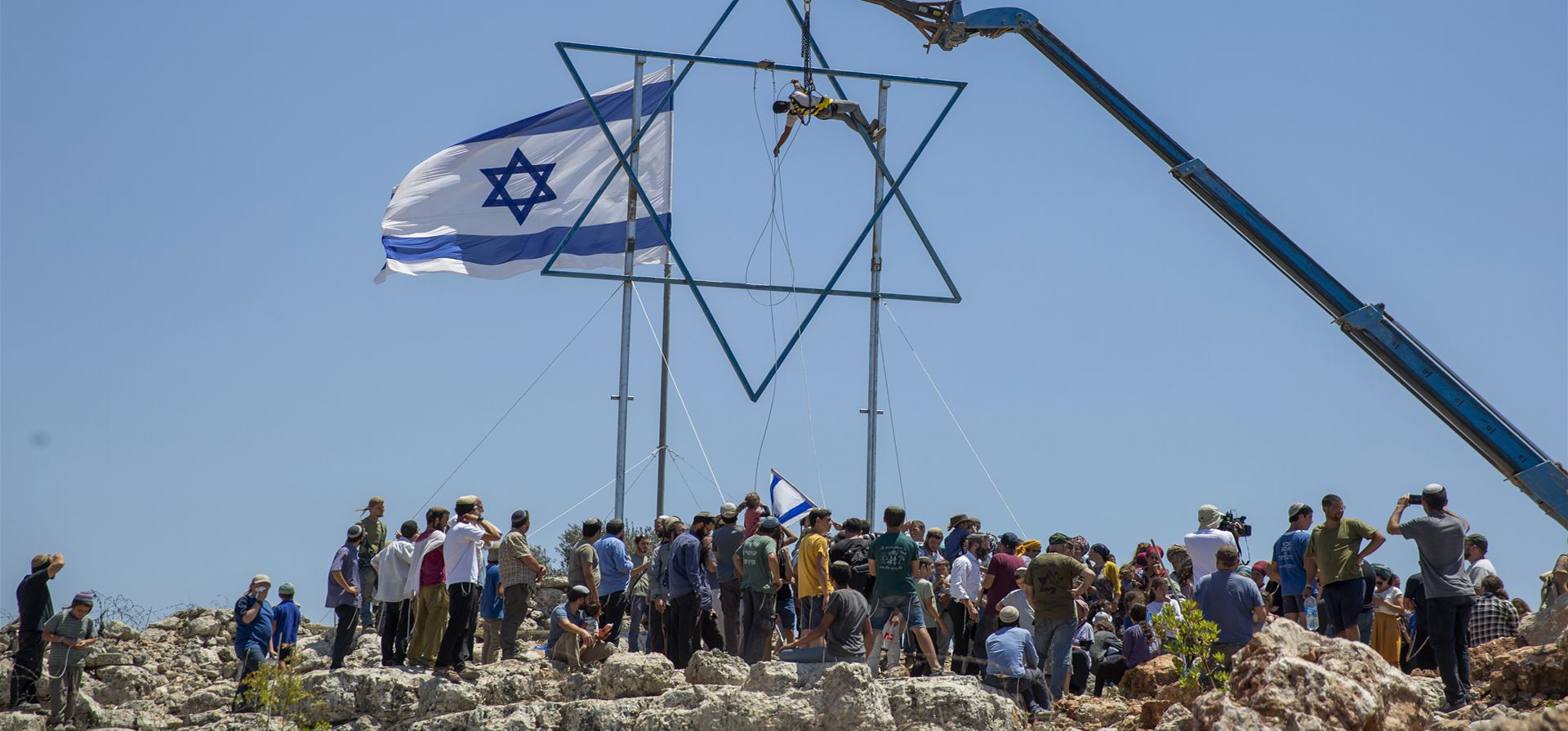 Un colono israelí ajusta una gran estrella de David en el puesto de Eviatar, recientemente establecido, cerca de la ciudad Cisjordana de Naplusa.