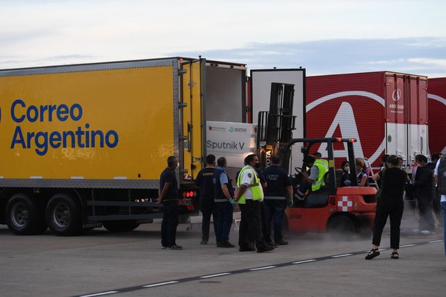 PISTA DE EZEIZA. Operarios traspasan las cajas de la bodega del avión a camiones del Correo y de Andreani.