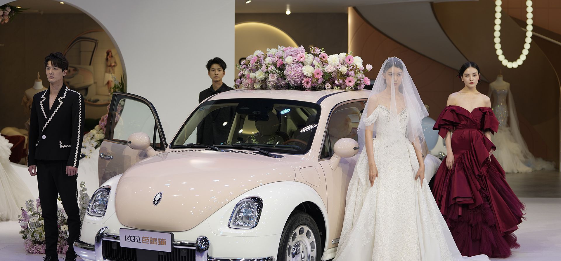 Modelos vestidos de novios para exhibir Ora, una marca de automóviles eléctricos de fabricación china durante el Auto Shanghai 2023 en el Centro Nacional de Exposiciones y Convenciones de Shanghái, China, el martes 18 de abril de 2023.  (Foto AP/Ng Han Guan)