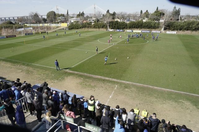 Con la gente de fondo, los jugadores trabajan ante la atenta mirada del cuerpo técnico.