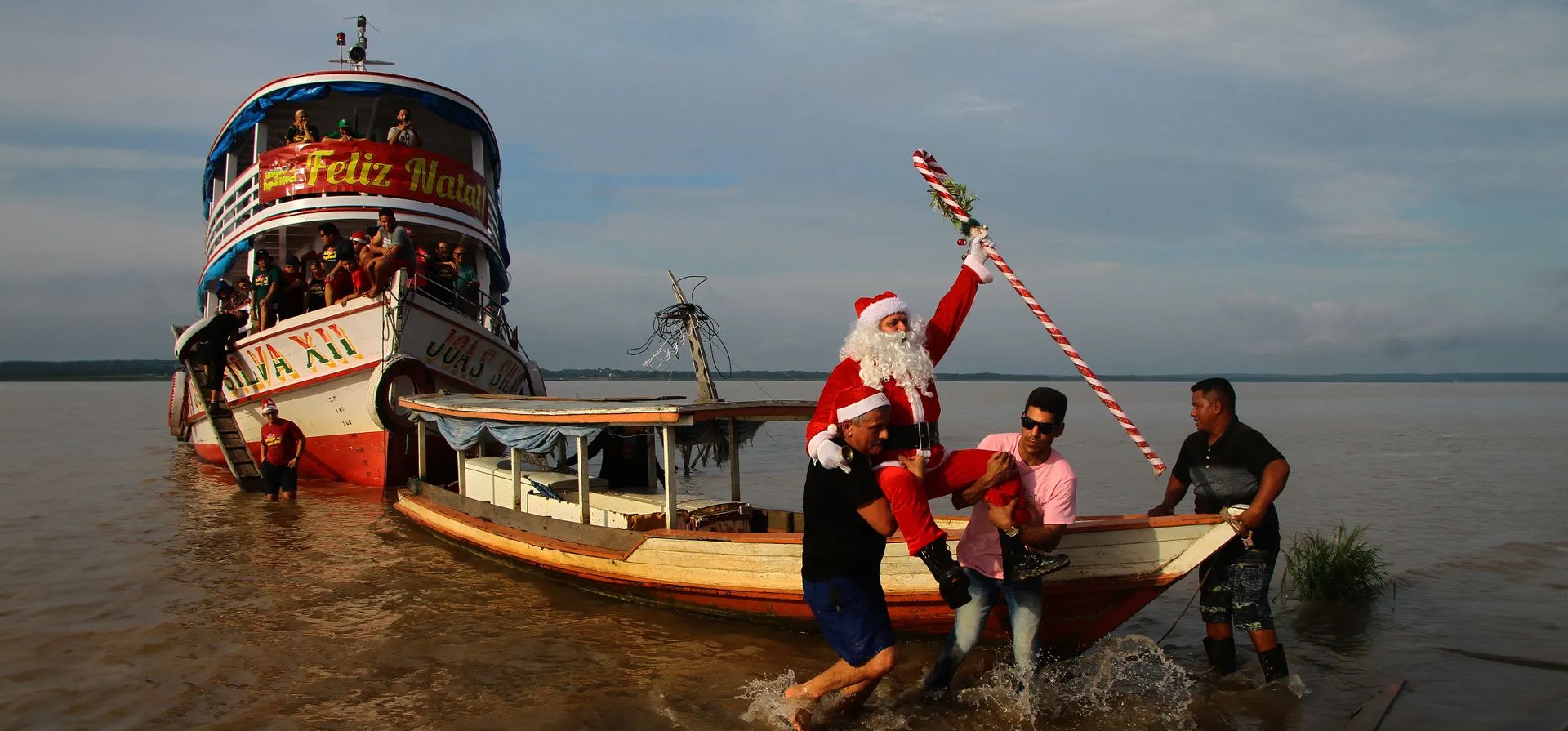 Vestido de Papá Noel, Jorge Barroso llega para repartir regalos a los niños de la cuenca del Amazonas, Careiro da Várzea, Brasil. Fotografía: Edmar Barros/AP Vestido de Papá Noel, Jorge Barroso llega para repartir regalos a los niños de la cuenca del Amazonas, Careiro da Várzea, Brasil. Fotografía: Edmar Barros/AP