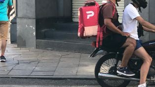 Por el centro. Este sábado, dos jóvenes se disponían a entregar hamburguesas que poco antes retiraron en San Martín y Córdoba.